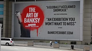 Il cartellone che pubblicizza la mostra di Banksy a Chicago.