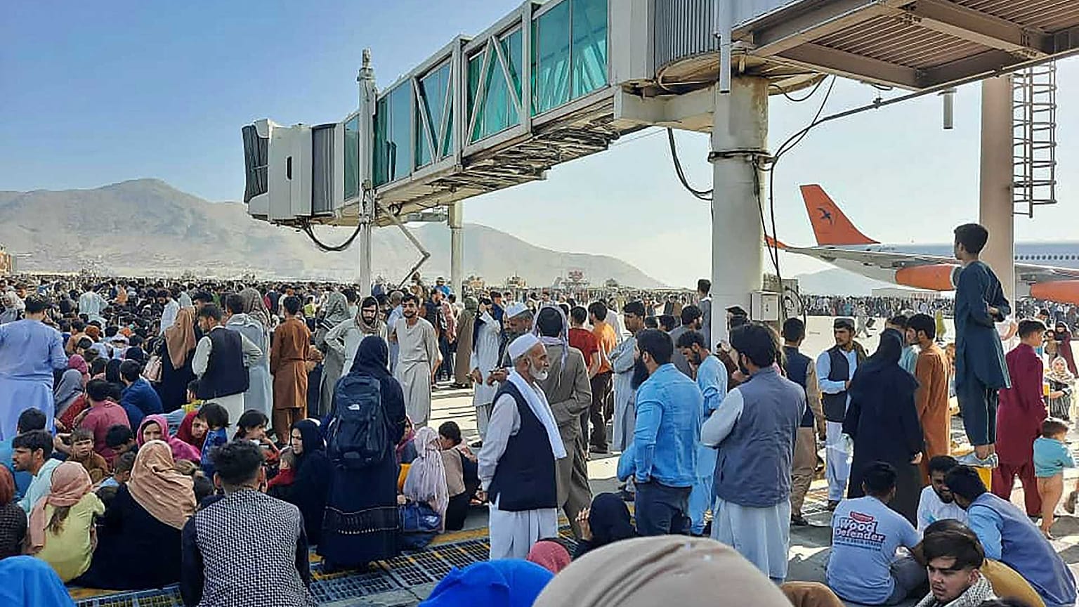 الأفغان يحتشدون في مطار كابل بينما يقف الجنود الأمريكيون في المدرج، أفغانستان، 16 أغسطس 2021.