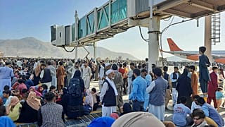 الأفغان يحتشدون في مطار كابل بينما يقف الجنود الأمريكيون في المدرج، أفغانستان، 16 أغسطس 2021.