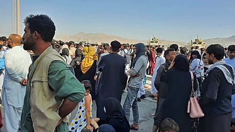 Des Afghans se pressent sur le tarmac de l'aéroport de Kaboul.