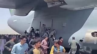 Afghans cling to a departing US military plane