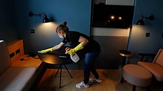 Un limpiadora de hotel prepara una habitación para los clientes