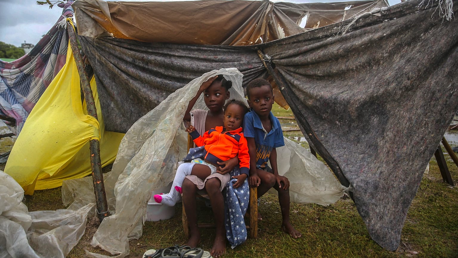 Niños desplazados por el terremoto se acurrucan bajo un trozo de plástico la mañana después de que la tormenta tropical Grace arrasara Les Cayes, Haití. 17 de agosto de 2021.