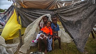 Niños desplazados por el terremoto se acurrucan bajo un trozo de plástico la mañana después de que la tormenta tropical Grace arrasara Les Cayes, Haití. 17 de agosto de 2021.