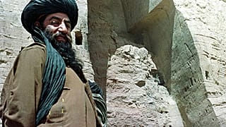 مسؤول في ميليشيا طالبان الأفغانية يقف بالقرب من أطول تمثال لبوذا قائم في مدينة باميا، في وسط أفغانستان ، 26 مارس 2001.