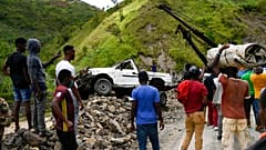 A crane removes a truck from a pile of rocks after landslides triggered by a 7.2-magnitude earthquake that hit four days prior in River Glass, Haiti, Wednesday, Aug. 18, 2021.