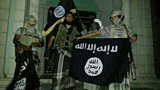 مقاتلو القاعدة يرفعون راية التنظيم أمام متحف في سيئون ثاني مدينة يمنية بمحافظة حضرموت.