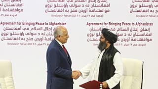 مبعوث السلام الأمريكي زلماي خليل زاد والملا عبد الغني بردار الزعيم السياسي الأعلى لحركة طالبان يتصافحان بعد توقيع اتفاق السلام في الدوحة، 29 فبراير 2020
