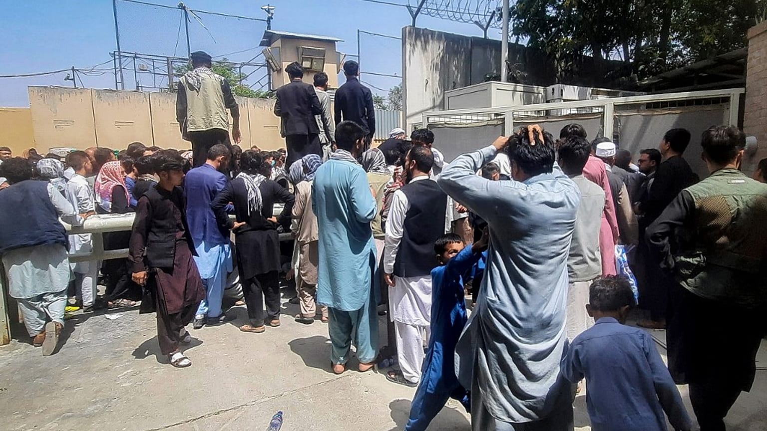 Afghan people gather outside the French embassy in Kabul.