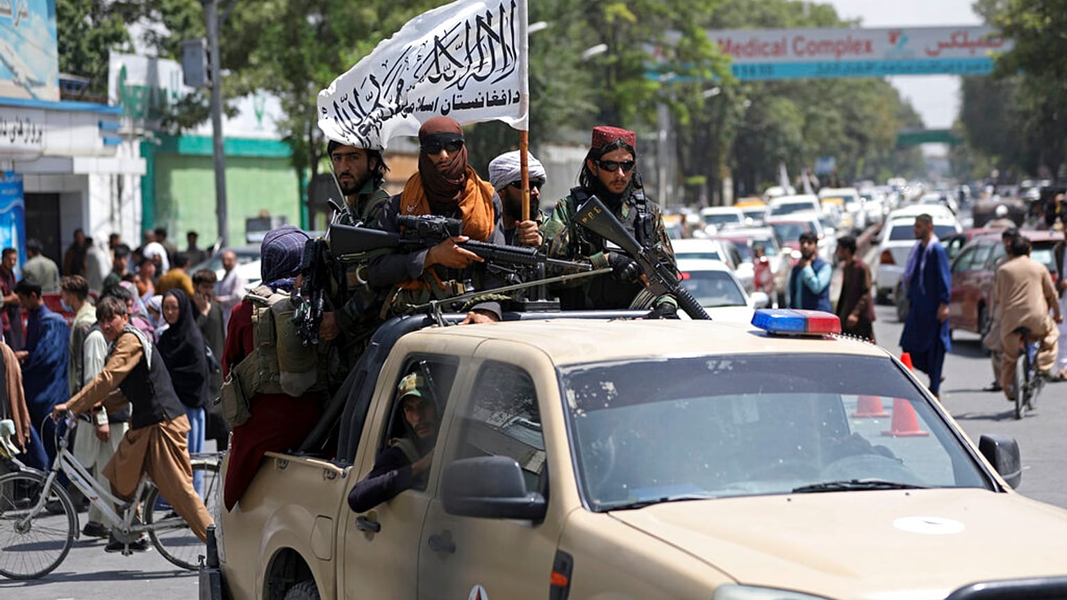 Combatientes talibanes exhibiendo su bandera por las calles de Kabul