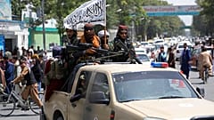Combatientes talibanes exhibiendo su bandera por las calles de Kabul