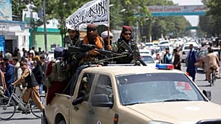 Combatientes talibanes exhibiendo su bandera por las calles de Kabul