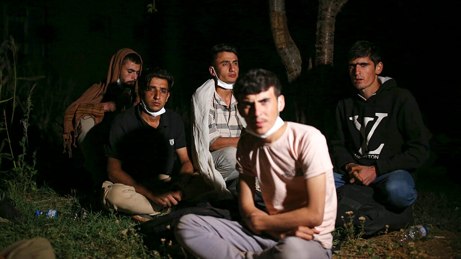 Afghan and Pakistani migrants sit in the countryside in Tatvan, in Bitlis Province, eastern Turkey, Wednesday, Aug. 18, 2021