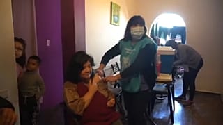 Imagen de una sanitaria poniendo la vacuna a un paciente en su casa de Buenos Aires.