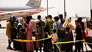 Civilians prepare to board an evacuation plane out of Kabul Airport.