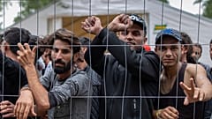 Migrantes detrás de una valla en el campo de refugiados recién construido en el campo de entrenamiento militar de Rudninkai, a unos 38 km al sur de Vilna.