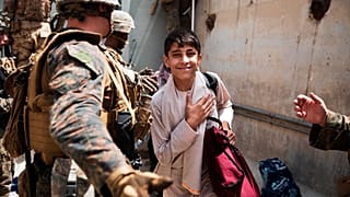 Afganistan'ın başkenti Kabil'deki Hamid Karzai Uluslararası Havaalanı'ndan uçakla ayrılmak üzere olan bir Afgan mülteci çocuk.