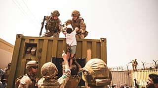 Un enfant afghan pris en charge par des soldats américains à l'aéroport de Kaboul (Afghanistan), le 20/08/2021 - photo fournie par l'armée américaine.