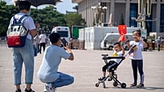 Children hold Chinese flags as they pose for a photo at Tiananmen Square in Beijing, on June 22, 2021. 