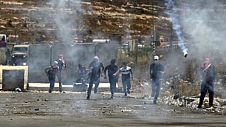 فلسطينيون يهرعون لتجنب قنابل الغاز المسيل للدموع خلال مظاهرة في 17 أغسطس 2021