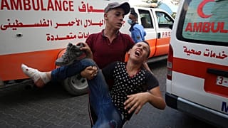 A protestor helps a wounded youth, who was shot by Israeli troops in his foot during a protest at the Gaza Strip's border with Israel.