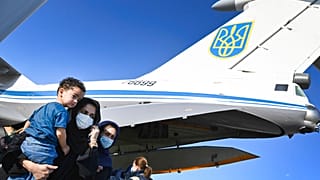 People evacuated from Afghanistan disembark from a Ukrainian military plane at Boryspil International Airport outside Kyiv, Ukraine