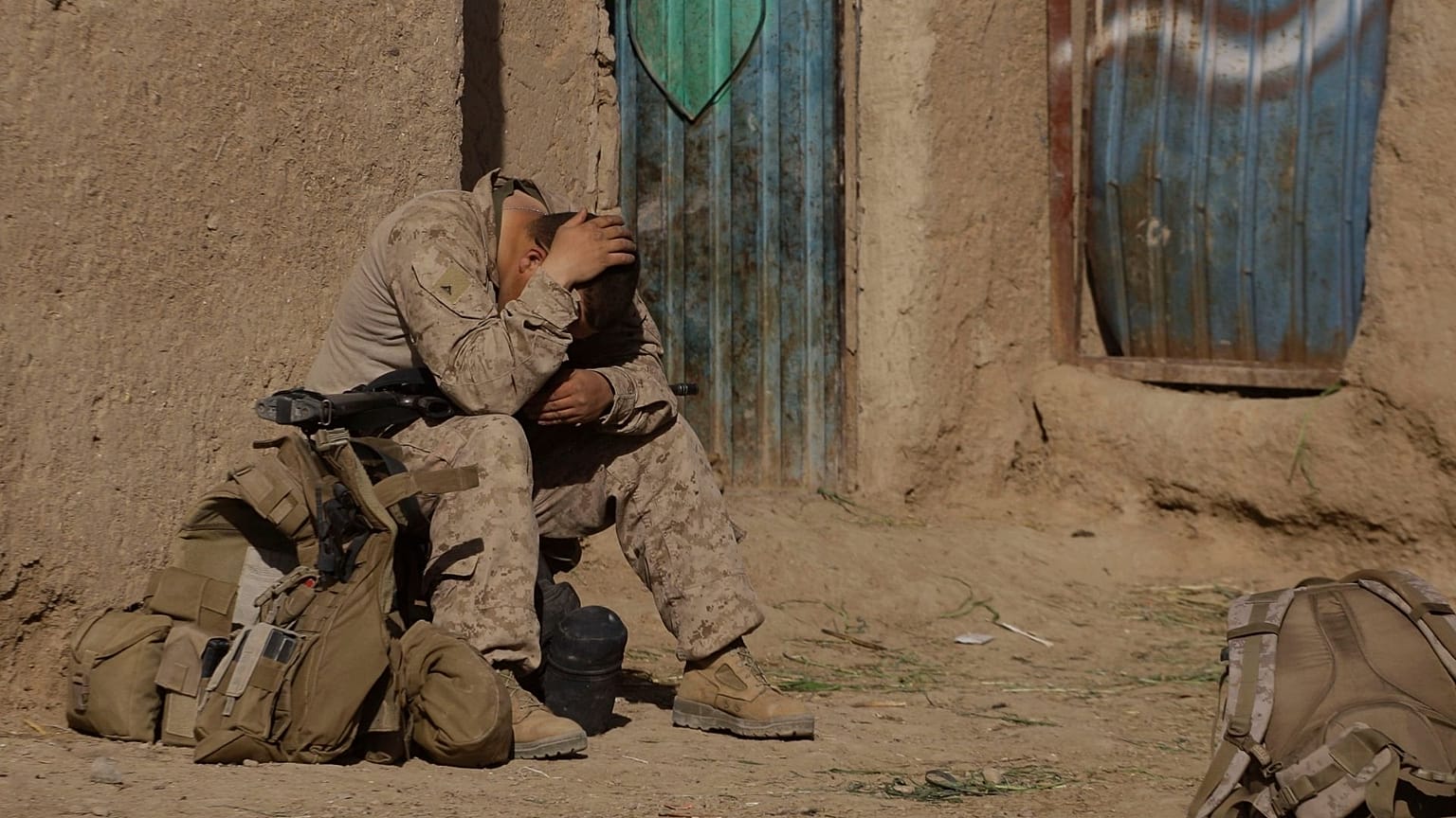A U.S. Marine from 3rd Battalion, 6th Marine Regiment sits alone after a patrol in Marjah in Afghanistan's Helmand province Friday, Feb. 19, 2010.