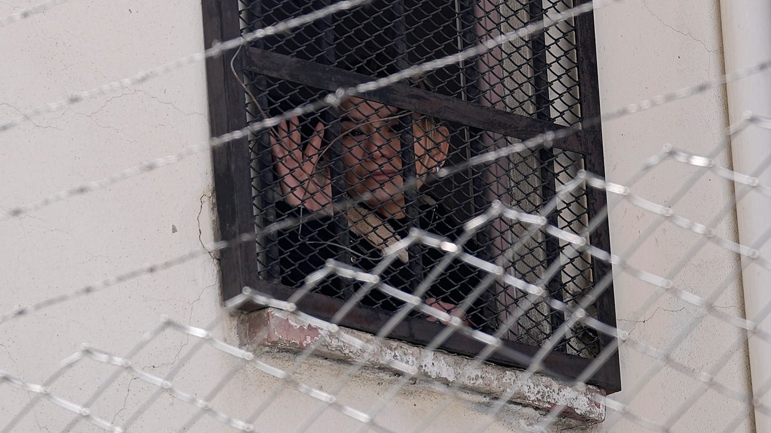 La expresidenta interina de Bolivia, Jeanine Anez, saluda desde una ventana de la cárcel de mujeres de Miraflores en La Paz, Bolivia, el 18 de agosto de 2021. 