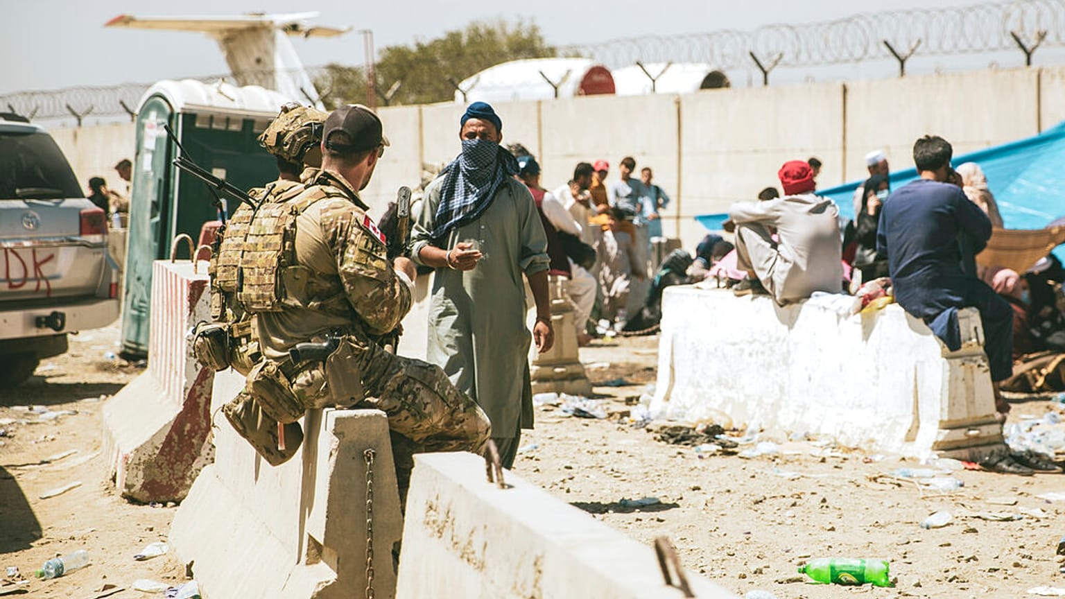 In this photo provided by the U.S. Marine Corps, Canadian coalition forces assist during an evacuation at Hamid Karzai International Airport in Kabul, Afghanistan