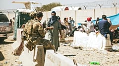 In this photo provided by the U.S. Marine Corps, Canadian coalition forces assist during an evacuation at Hamid Karzai International Airport in Kabul, Afghanistan