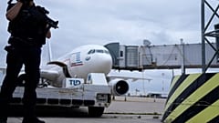 A gendarme guards a government plane carrying people from Kabul at the Roissy Charles Gaulle airport, north of Paris.