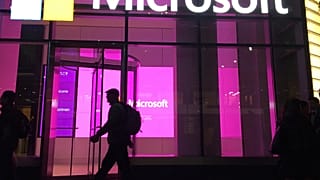 In this Nov. 10, 2016, file photo, people walk past a Microsoft office in New York.