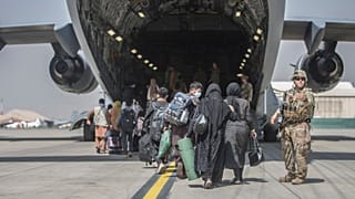 Családok szállnak be egy amerikai kimenekítő repülőgépbe a kabuli reptéren