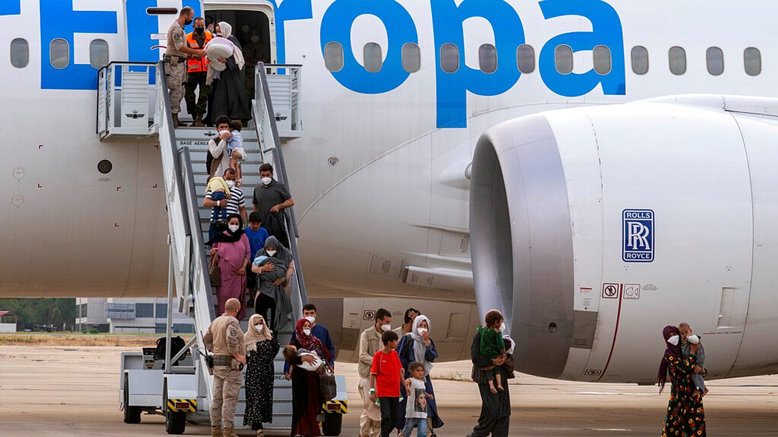 Afghan people who were transported from Afghanistan, disembark after landing at the Torrejon military base as part of the evacuation process in Madrid, Spain, August 24, 2021.