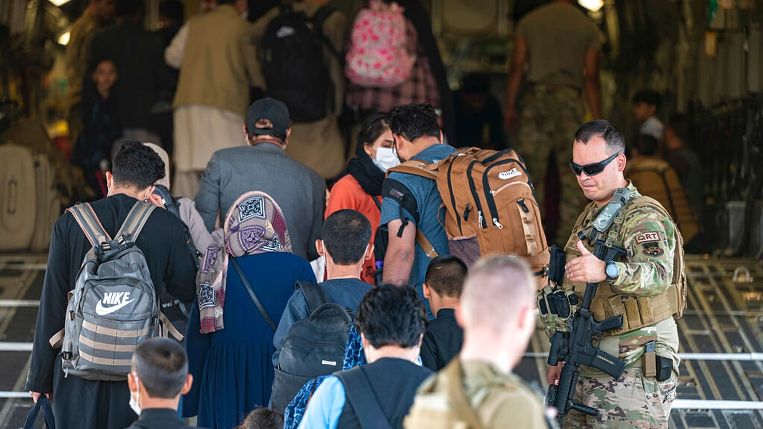 In this image provided by the U.S. Air Force, U.S. Air Force airmen guide evacuees aboard a US Air Force plane at Hamid Karzai International Airport, August 24, 2021. 