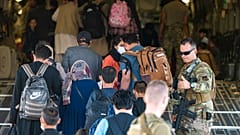 In this image provided by the U.S. Air Force, U.S. Air Force airmen guide evacuees aboard a US Air Force plane at Hamid Karzai International Airport, August 24, 2021. 