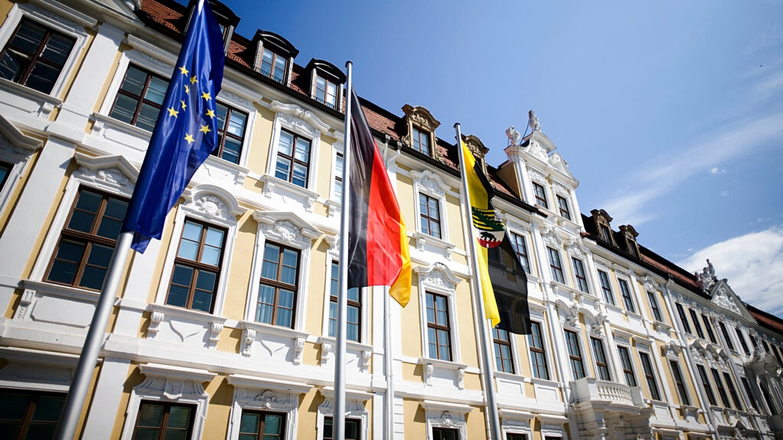 Europäische, deutsche und sachsen-anhaltische Flagge vor dem Landtag in Magdeburg, Juni 2021