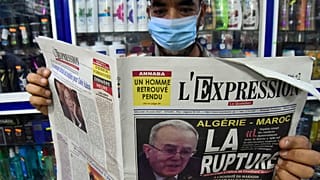 Un algerino con il giornale del 25 agosto 2021 sul quale si legge "La rottura"