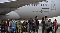 Refugees queue on the tarmac after disembarking from an evacuation flight from Kabul, at the Torrejon de Ardoz air base, 30 km from Madrid, on August 24, 2021.