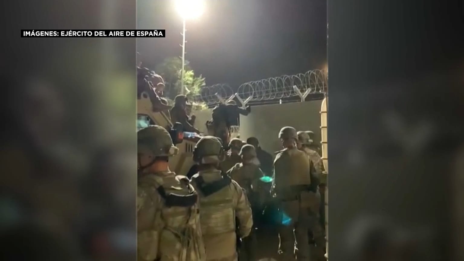 Militares españoles esperan a un grupo de afganos en las pistas del aeropuerto de Kabul.