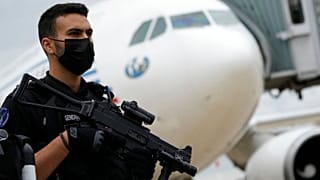 یک مامور ژاندارمری فرانسه در کنار هواپیمای حامل افغان‌های منتقل شده به فرودگاه شارل دو گُل پاریس