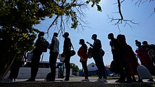 En esta foto de archivo del 16 de junio de 2021, los migrantes hacen cola en un centro de descanso después de cruzar la frontera entre Estados Unidos y México