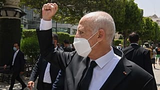 الرئيس التونسي قيس سعيد قبضته أمام المارة أثناء تجواله على طول شارع بورقيبة في تونس العاصمة، الأحد 1 أغسطس 2021
