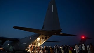 Cette photo prise le 26 août 2021 montre des personnes embarquant dans un avion militaire français à l'aéroport de Kaboul