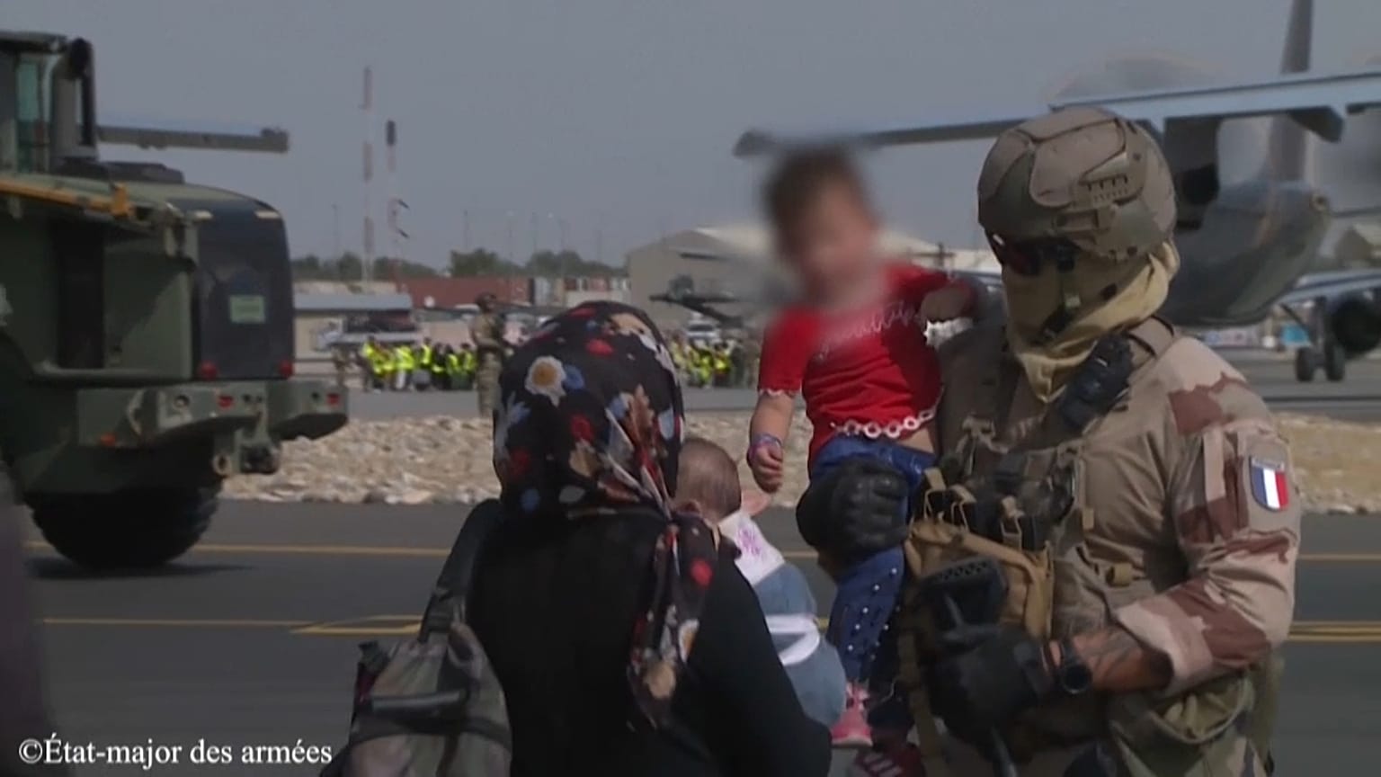 Image d'un soldat français tenant par la main un enfant afghan sur l'aéroport de Kaboul, Afghanistan, 23 août 2021