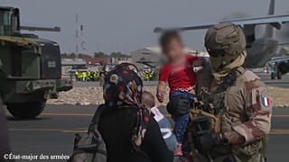 Image d'un soldat français tenant par la main un enfant afghan sur l'aéroport de Kaboul, Afghanistan, 23 août 2021