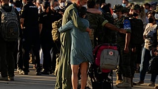 Un soldado español abraza a una mujer tras la llegada del avión procedente de Afganistán A la base militar de Torrejón de Ardoz en Madrid, el 27 de agosto de 2021.