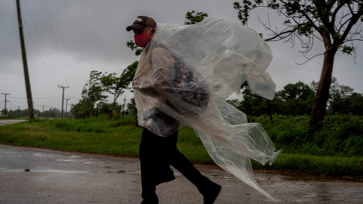 Un hombre se protege de la lluvia con un plástico en Cuba
