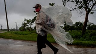Un hombre se protege de la lluvia con un plástico en Cuba