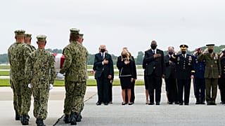 President Joe Biden watches as a Navy carry team moves a transfer case containing the remains of Navy Corpsman Maxton W. Soviak, 22, of Berlin Heights, Ohio, Sunday, Aug. 29.